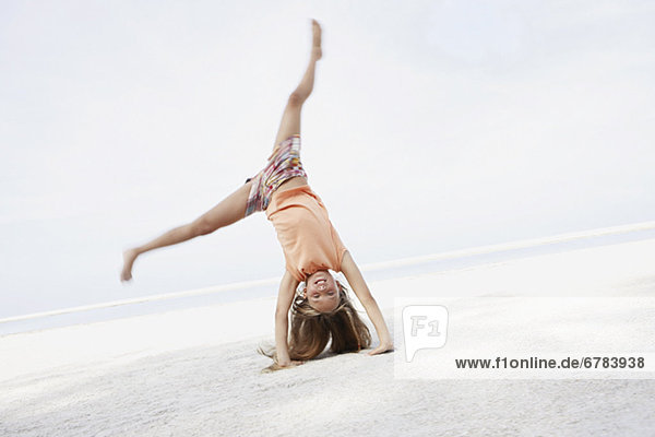 Girl doing Cartwheel am Strand