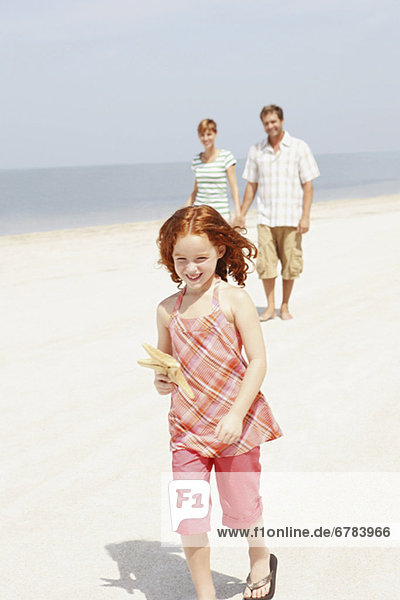 Couple and daughter walking on beach