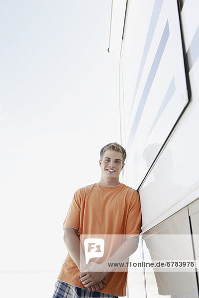 Young man leaning against motor home
