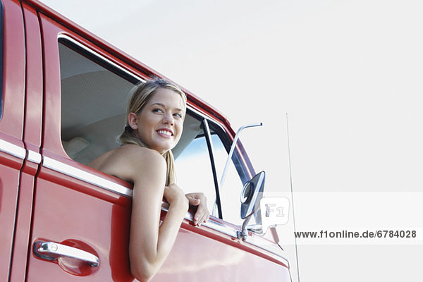 Young woman leaning out of van window