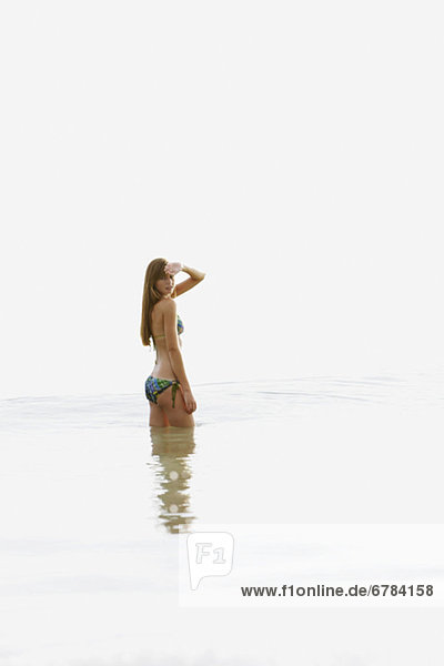 Teenage girl wading in ocean