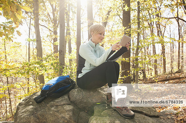 Female hiker using digital tablet in forest