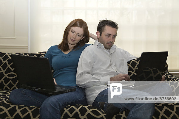 Young couple using laptops  Whitby  Ontario