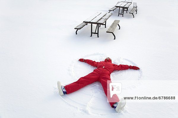 Senior woman making a snow angel  Algonquin Park  Ontario