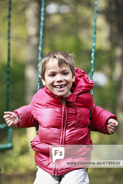 Boy with missing tooth  playing on swing  Gimli  Manitoba