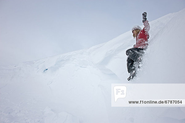 Girl sliding in snow  Haines Summit  British Columbia
