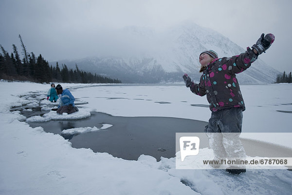 Happy girl on ice floe of freezing lake  Kathleen Lake  Kluane National Park  Yukon Territory  Canada
