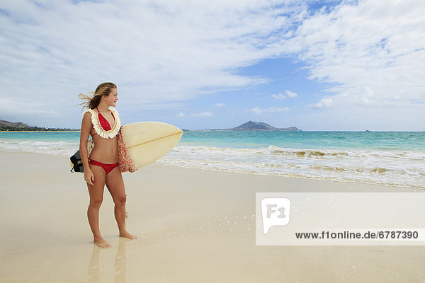 Hawaii  Oahu  Kailua Beach  Teenage girl holding surfboard on beach.