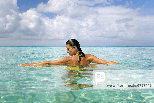 Woman relaxing in tropical ocean water.