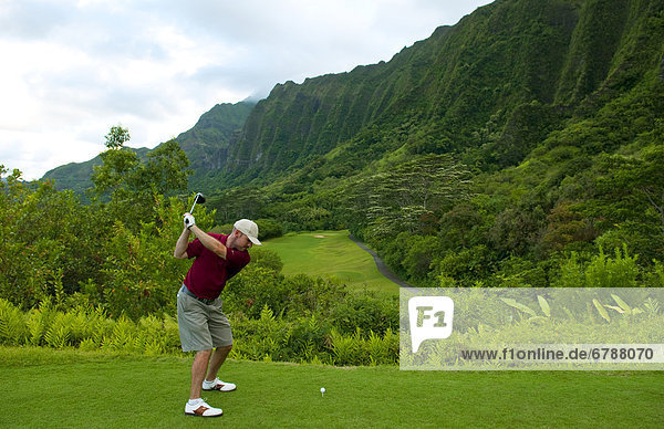 Hawaii Oahu Honolulu Ko'olau Golf Course Man driving on the 15th hole with beautiful mountain view.