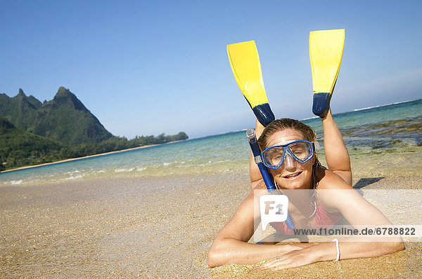 Hawaii  Kauai  Tunnels Beach  eine Frau tragen gelbe und blaue Flossen und Schnorcheln Gear am Strand.