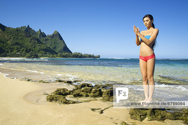 Hawaii  Kauai  North Shore  Tunnels Beach  Frau macht Yoga.