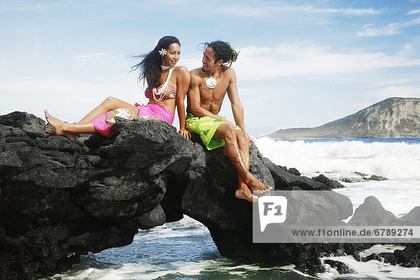 Hawaii  Oahu  Makapuu  männlich und weiblich Hula Tänzern sitzen auf ein Rock posing.