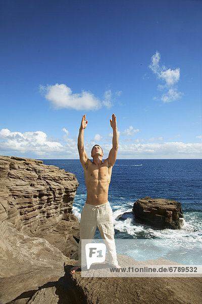 Hawaii  Oahu  Male tun Yoga auf felsigen Klippe.
