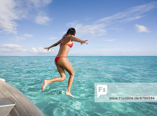 Französisch-Polynesien  Moorea  junge Frau springt in den Ozean.