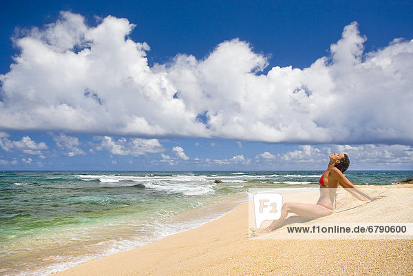 Hawaii  Kauai  North Shore  Frau sitzt am Strand.