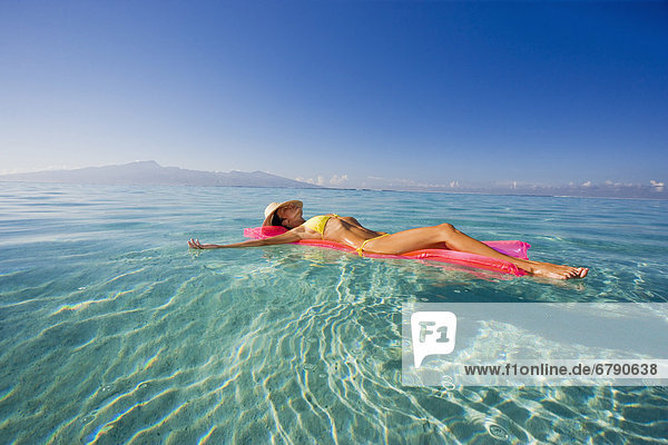 Französisch-Polynesien  Tahiti  Moorea  Frau im Wasser schweben.