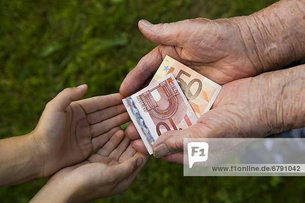 Alte Frau gibt Kind Geld  Euro-Scheine
