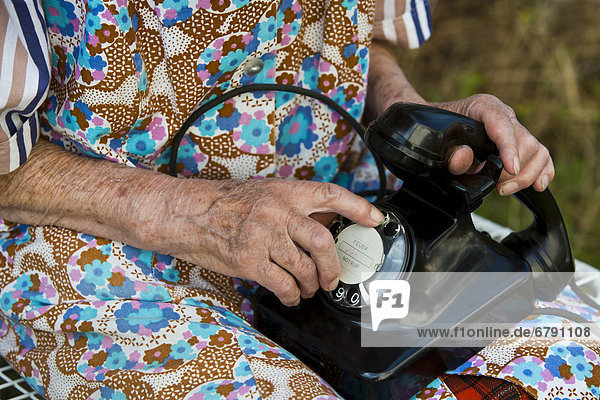 Alte Frau wählt auf historischem Telefon