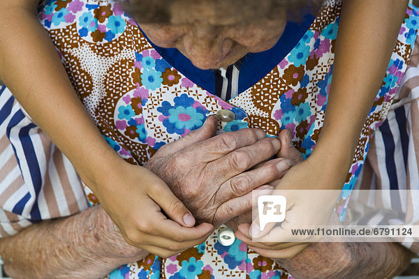 Kind umarmt alte Frau