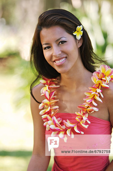 Hawaii  Oahu  lokalen Mädchen mit gelben Plumeria hinter ihr Ohr und ein Plumeria Lei um den Hals.