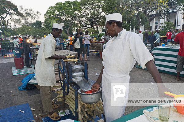 Food vendors making sugarcane juice in Forodhani Gardens  Stone Town  Zanzibar  Tanzania  Africa