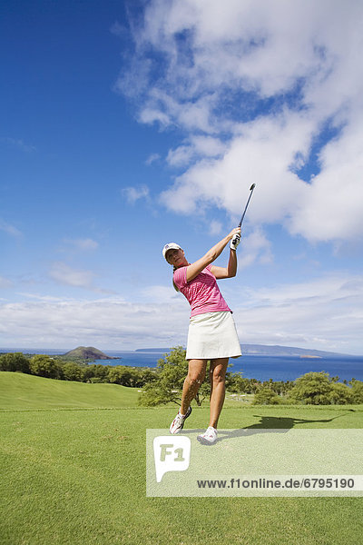 Hawaii  Maui  Wailea Gold Golf Course  Female golfer swinging golf club.