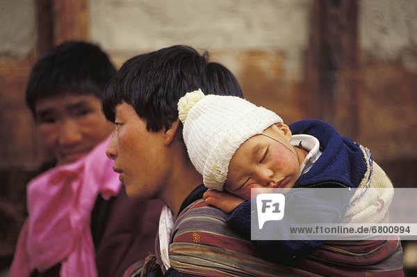 Man Carrying Baby On His Back  Jakar  Bhutan