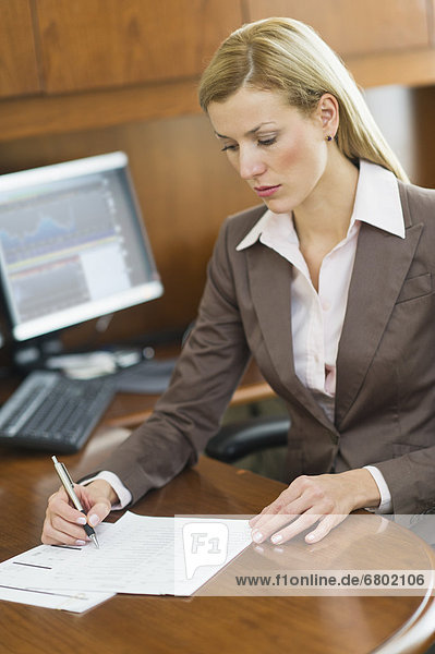 Businesswoman writing at desk