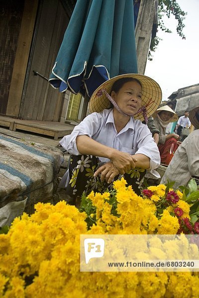 Vender Selling Flowers At An Open Air Market  Hoi An Vietnam