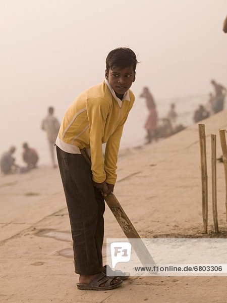 Young Boy Playing Cricket By The Ganges  Ganges River Varanasi India