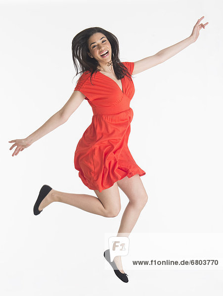 Studio portrait of young woman jumping