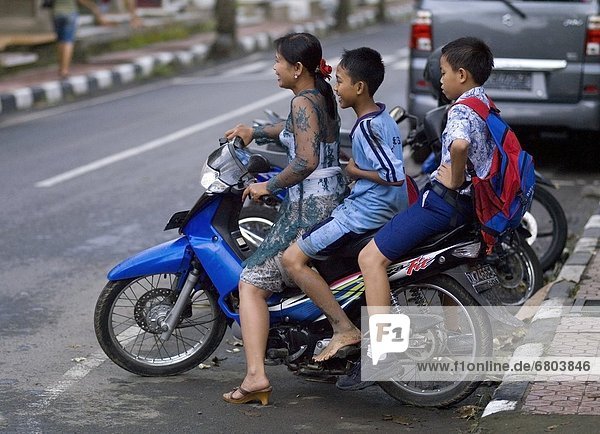 Woman On Motorcycle With Two Children