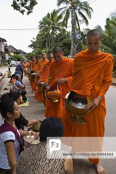 Buddhist Monk Getting Offerings From Crowd