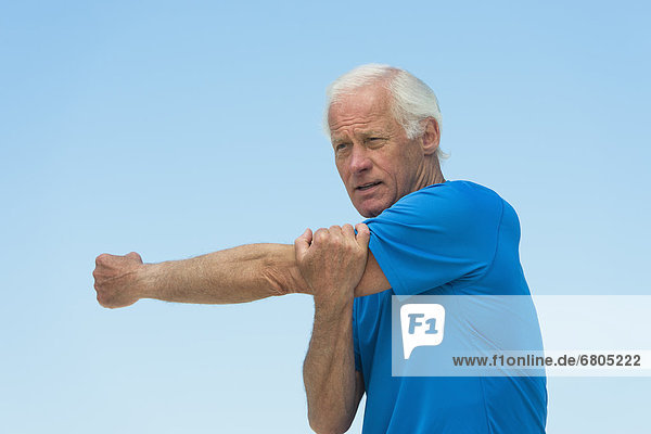 Senior man stretching outdoors