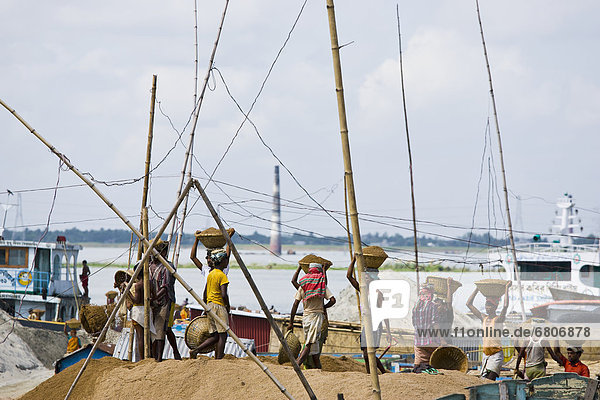 People Unloading A Barge Of Sand With Baskets  Dhaka  Bangladesh