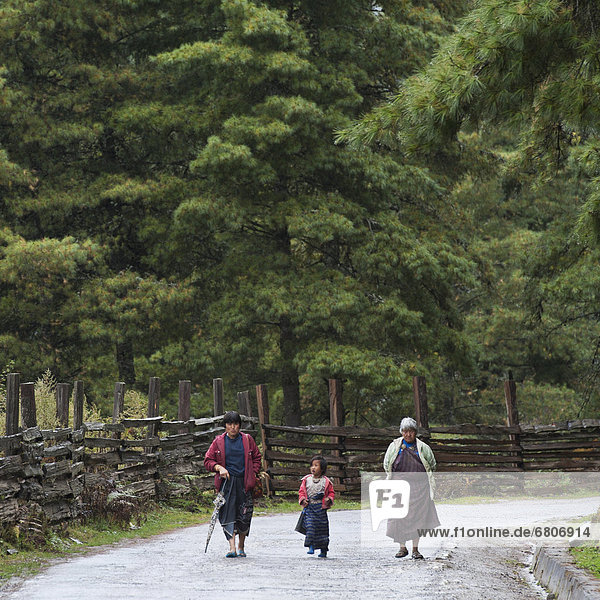 People Walking Along Rural Road  Phobjikha Valley Bhutan