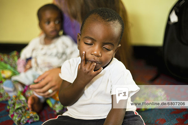 ugandisches Kind mit Fingern im Mund  Sanyu Babies Home