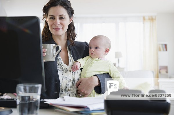Mother with baby boy (2-5 months) working from home