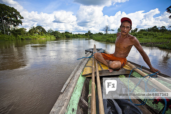 A Shirtless Man Sits In A Wooden Boat On The Water  Tanjung Lubuk Sumatera Selatan Indonesia