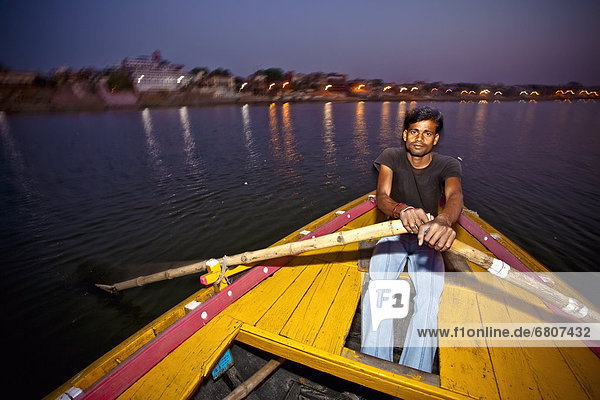 A Young Man Rows A Boat Along The Ganges River Early In The Morning  Varanasi India