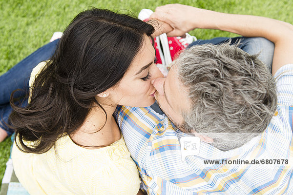 Happy couple kissing on grass