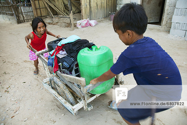 Two Kids Pull A Cart Through A Village  El Nido Bacuit Archipelago Palawan Philippines