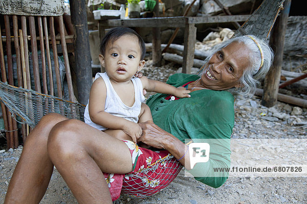 A Grandmother Holds Her Grandchild In A Village  El Nido Bacuit Archipelago Palawan Philippines
