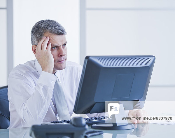 Portrait of worried businessman working at desk