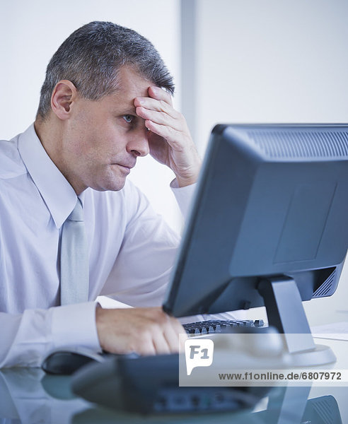 Portrait of worried businessman working at desk