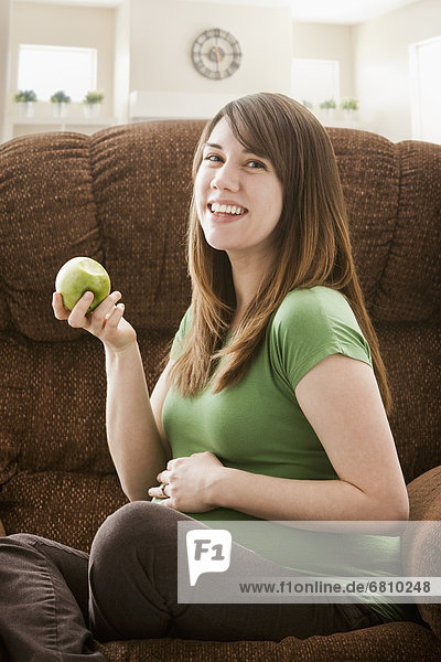 sitzend  Portrait  Frau  Couch  Schwangerschaft  Apfel  essen  essend  isst
