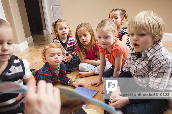 Children (2-3  4-5) sitting on floor and learning