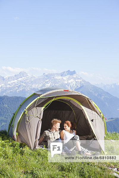 Switzerland  Leysin  Hikers resting in tent pitched on meadow