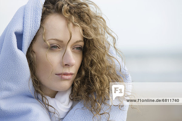 Portrait of young woman wrapped in blanket